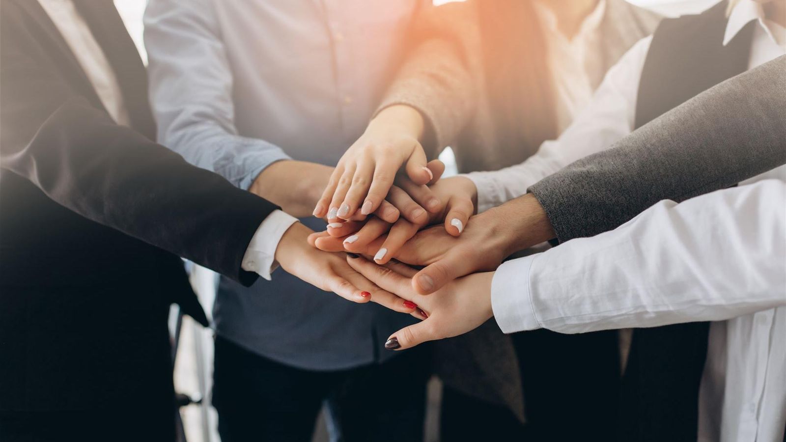 Viele Hände liegen übereinander als Zeichen für gemeinsames Commitment