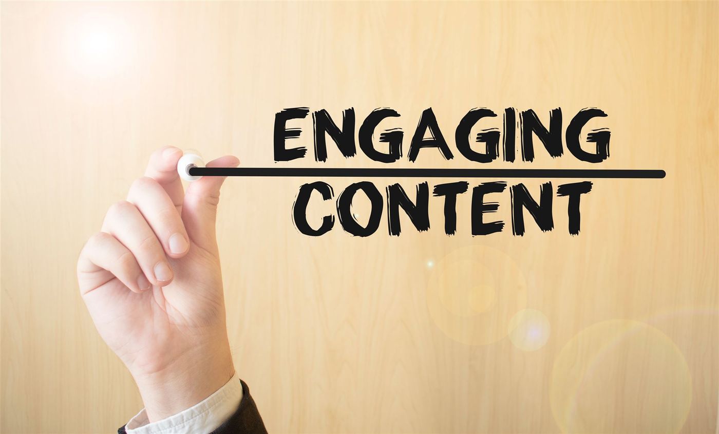 Hand schreibt „Engaging Content“ auf eine Holzwand