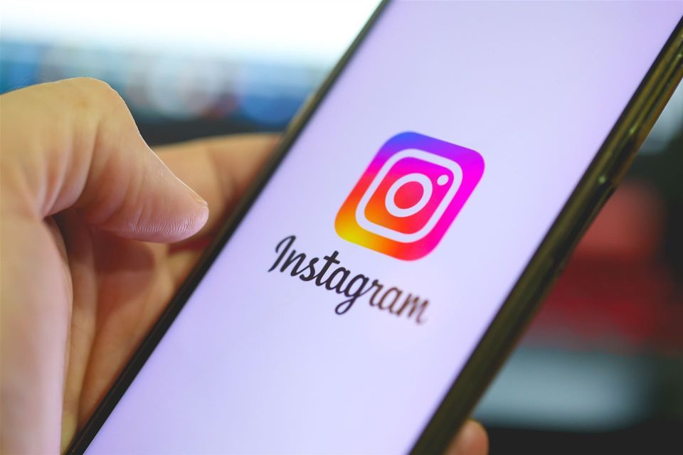 Hand hält ein Smartphone mit dem Instagram-Logo